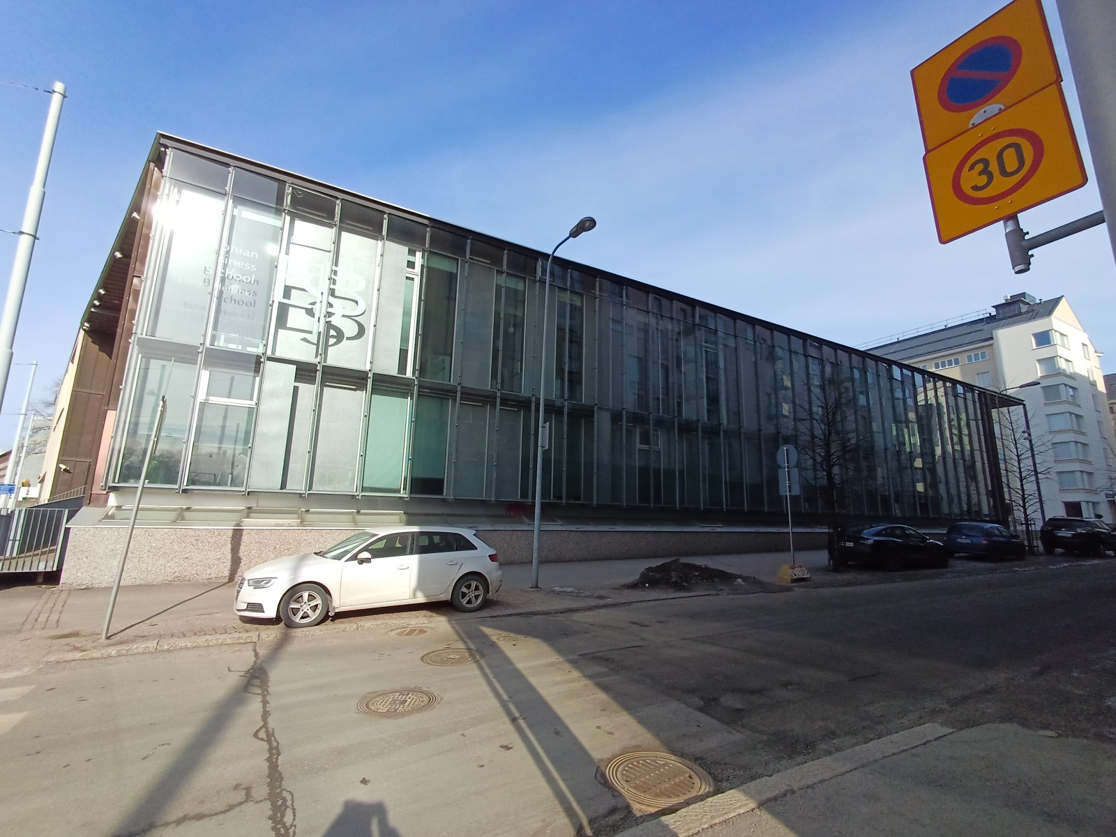 The long glass wall of Domus Gaudium along Leppäsuonkatu, with a white ESB logo at its left end, near Mechelininkatu.